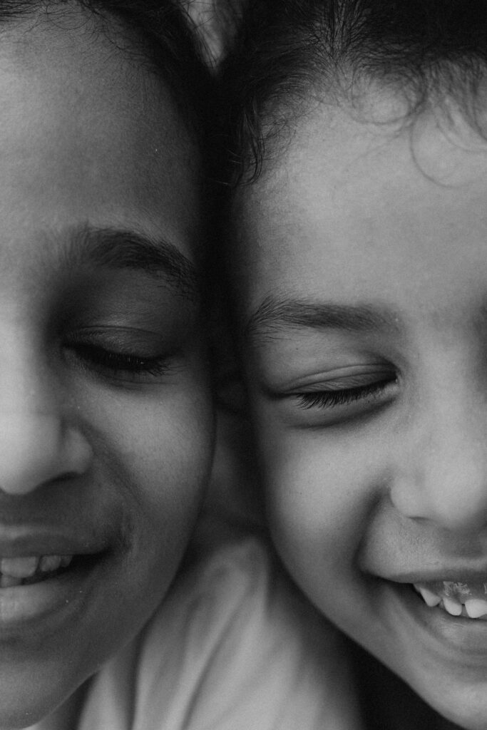 pexels-photo-28291427-28291427 Black and white portrait of two smiling children, capturing joy and friendship.